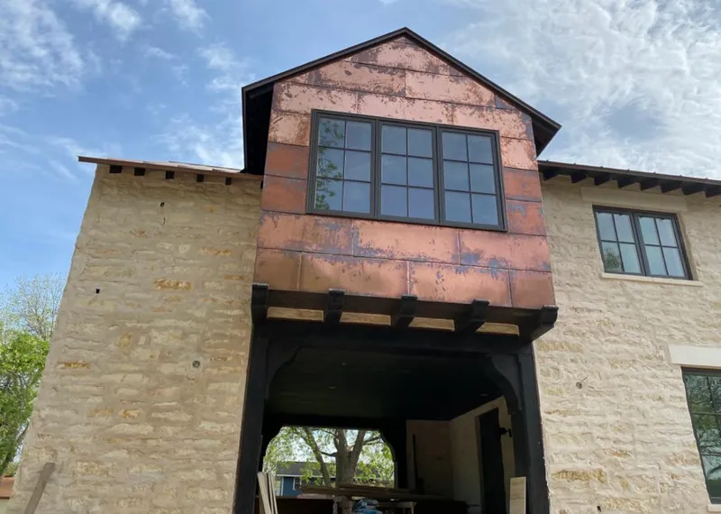 Copper metal panel facade on a stone building for Roof Repair in Granite Shoals